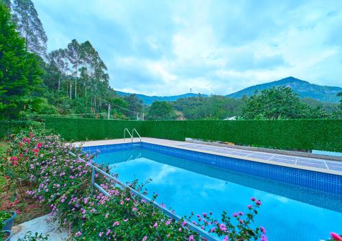 a swimming pool with mountains in the background at Ministers Mansion Kanthalloor Pool Resort by VOYE HOMES in Kanthalloor