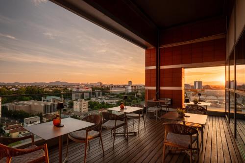 a balcony with tables and chairs and a view of the city at Savhotel Mantegna Padova in Padova