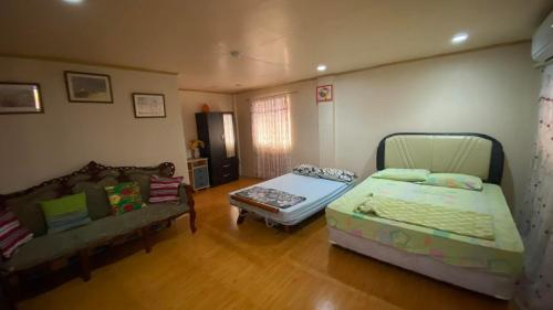 a living room with a bed and a couch at Buku Island House in san juan la union