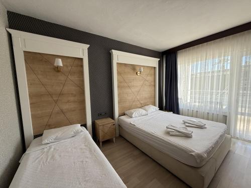a bedroom with two beds and a window at Özsoy Otel in Akçay