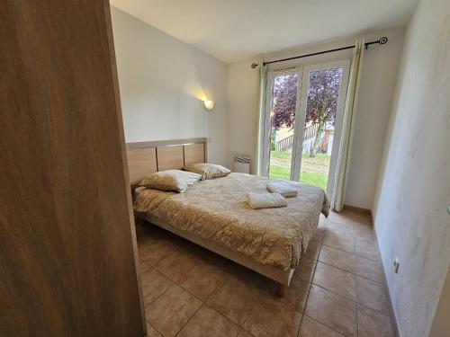 a bedroom with a bed and a large window at Appartement T3 Barbaste in Barbaste