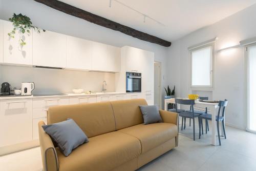 a living room with a couch and a kitchen at GuestHost - Vivaldi Estate Apartment in Treviglio