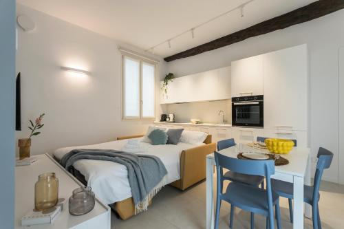 a bedroom with a bed and a table and chairs at GuestHost - Vivaldi Estate Apartment in Treviglio