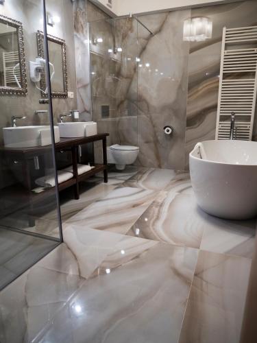 a bathroom with a sink and a tub and a toilet at Best Western Silva Hotel in Sibiu