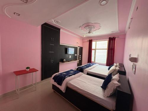 two beds in a room with pink walls at Pine View Guest House in Nāhan