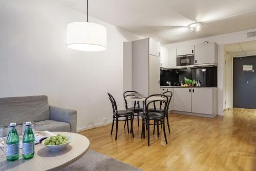 a living room with a couch and a table and chairs at Story Living Lidingö in Stockholm