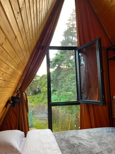 a bedroom with a window looking out at a field at Ja ge • ჟა ღე in Tsalka