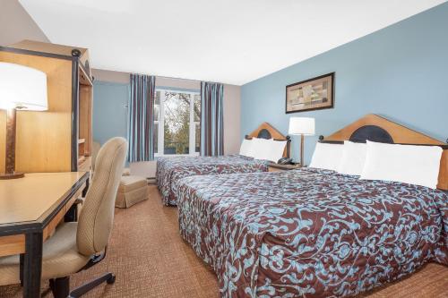 ein Hotelzimmer mit einem Bett und einem Schreibtisch in der Unterkunft Belmont Inn in Sudbury