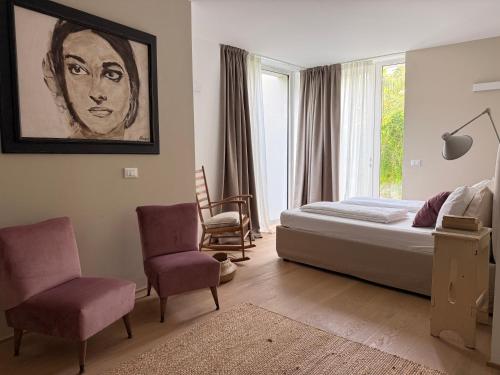 a bedroom with a bed and a painting of a woman at Villa Prince Garda in Salò