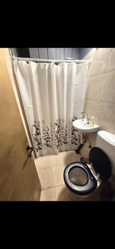 a bathroom with a toilet and a shower curtain at Slice of life in Qiryat Motzkin