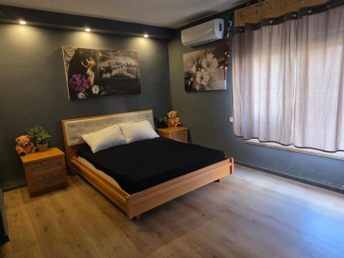 a bedroom with a bed and a window at Slice of life in Qiryat Motzkin