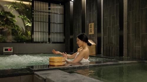 a woman sitting in a bathtub in a building at Anook Hotel & Spa Bucheon Sangdong in Bucheon