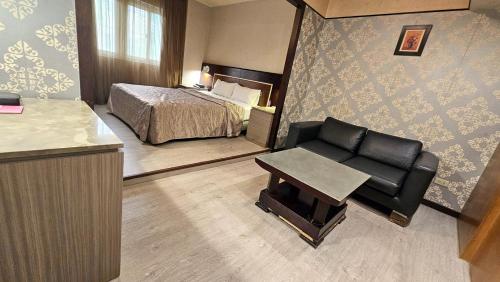 a hotel room with a bed and a chair at Beckham Motel in Luzhu