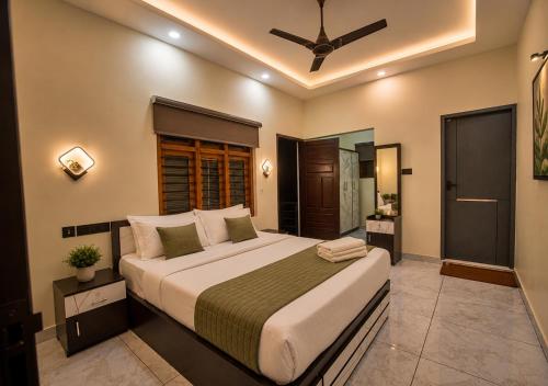 a bedroom with a large bed in a room at De Waves Varkala by VOYE HOMES - Just 1 Km from Varkala Cliff and Beach in Varkala