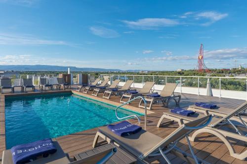a pool on the roof of a building with chairs at H10 Salauris Palace in Salou