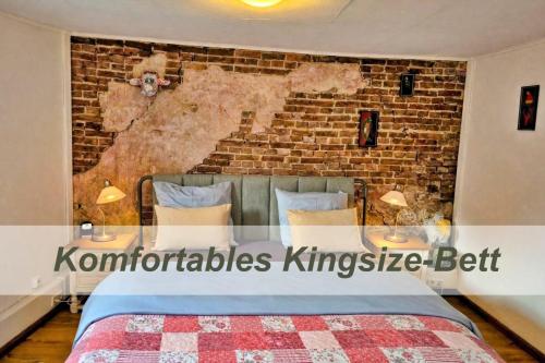 ein Schlafzimmer mit einer Ziegelwand und einem Bett in der Unterkunft Bed Bentheim in Bad Bentheim