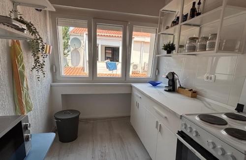 a kitchen with white cabinets and a window in it at SeaFun Apartment Gajac in Gajac
