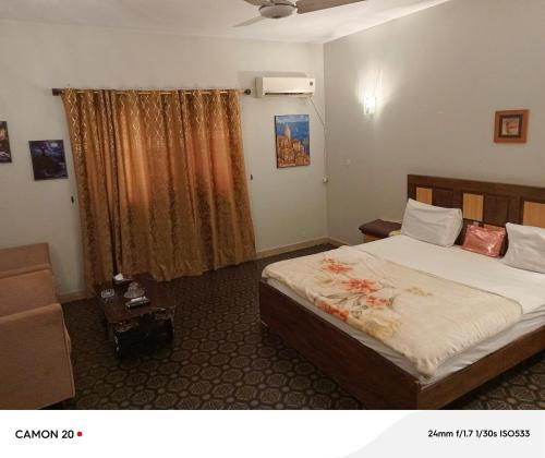 a hotel room with a bed and a couch at Hotel Royal Inn in Karachi