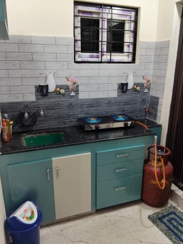 a kitchen with a blue counter and a sink at Venya Vihar Vizag MVP AC Deluxe 1 BHK Studio Apartment in Visakhapatnam