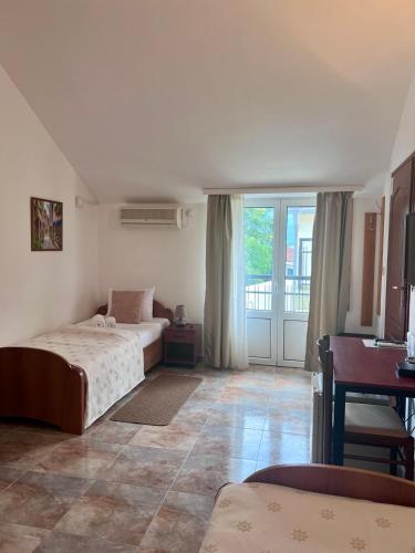a bedroom with two beds and a large window at Hotel Max in Baošići