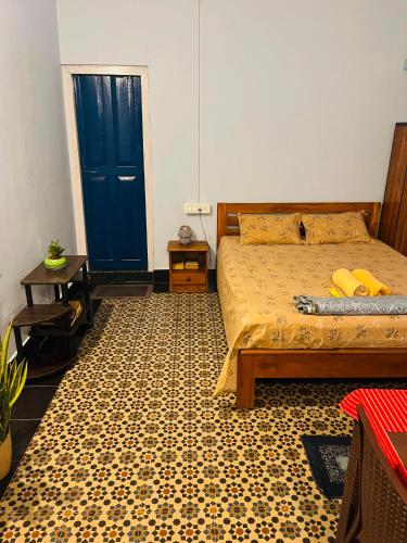 a bedroom with a bed and a blue door at Org Retreat & Farmstay in Guwahati