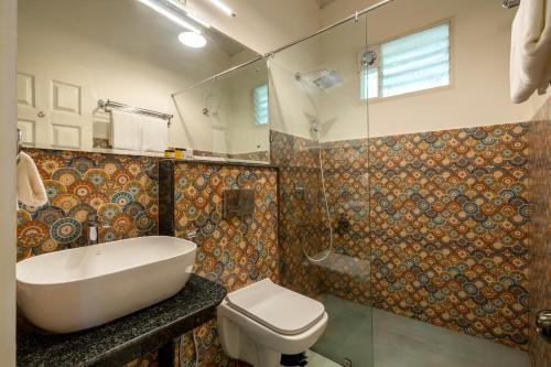 a bathroom with a tub and a toilet and a shower at Ashvana Resort in Nidigere
