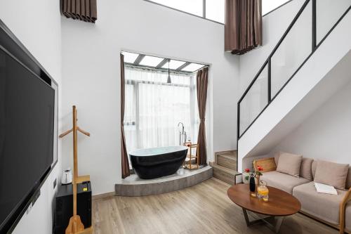 a living room with a bath tub and a couch at Ruqi Hotel in Yangshuo