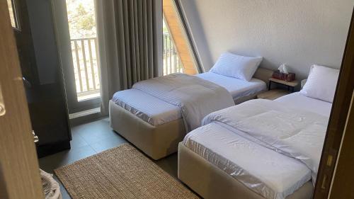 a room with two beds and a window at Apex Hills تلال القمة in Dār Sawdāʼ
