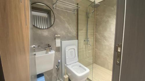 a bathroom with a toilet and a sink and a mirror at Apex Hills تلال القمة in Dār Sawdāʼ