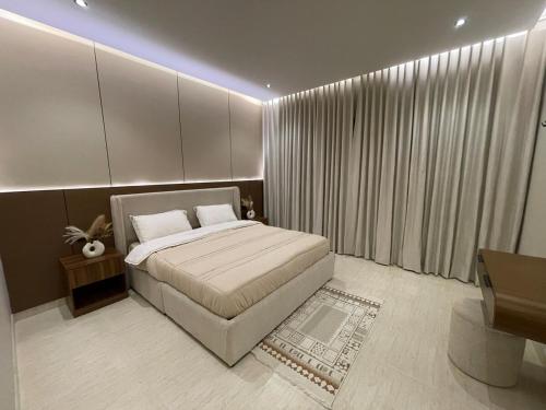 a bedroom with a bed and a large window at أواسِيس Oasis Stay in Al Muḩassin