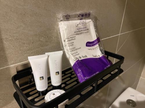 a black rack with someorative products in a bathroom at أواسِيس Oasis Stay in Al Muḩassin