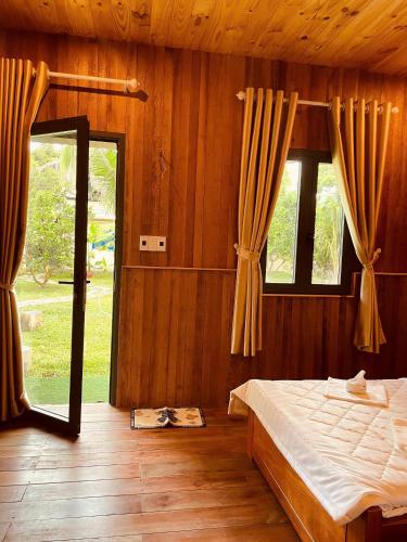 a bedroom with a bed and a large window at Homestay CÂY THỊ in Tây Ninh