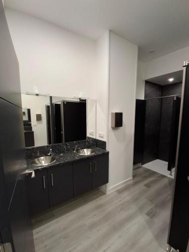 a bathroom with two sinks and a large mirror at Albergue Adventus in Padrón