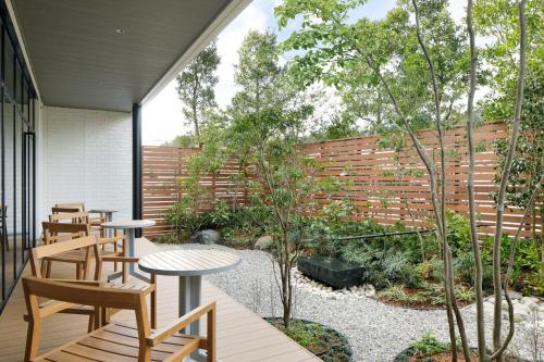 a patio with tables and chairs and a garden at Fairfield by Marriott Mie Okuise Odai in Odaicho