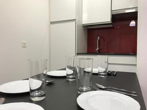 una mesa negra con platos y vasos. en Smart-Tech Plaza Apartment, en Salamanca