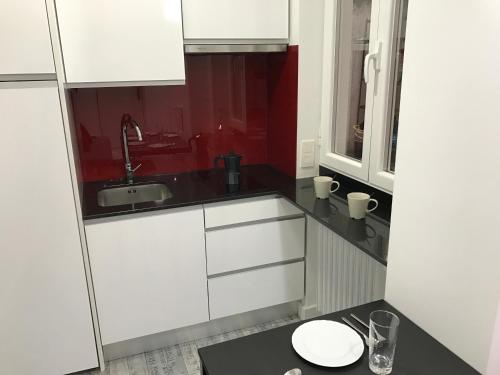 una piccola cucina con armadi bianchi e lavandino di Smart-Tech Plaza Apartment a Salamanca