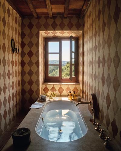 a large bath tub in a bathroom with a window at Le Lappe in Cavriglia