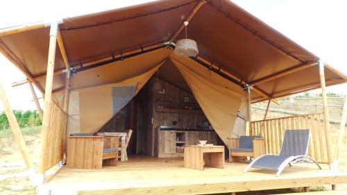 a tent with a table and chairs in it at Retour Au Source in Monprimblanc