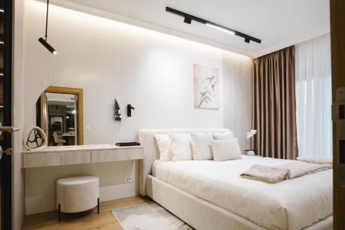 a white bedroom with a large bed and a mirror at CIA apartmani - Arandjelovac Bekatown Apartment in Arandelovac