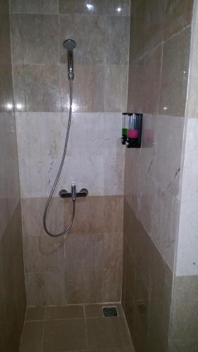 a shower with a hose in a bathroom at Legenda Beril Hostel in Makassar