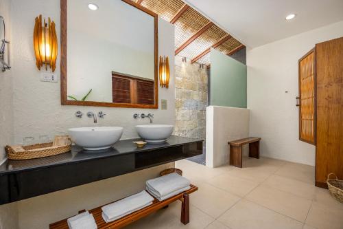 a bathroom with two sinks and a mirror at Bluewater Maribago Beach Resort in Mactan