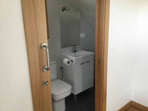 ein Badezimmer mit einem WC, einem Waschbecken und einem Spiegel in der Unterkunft Linar Do Rei in Linares