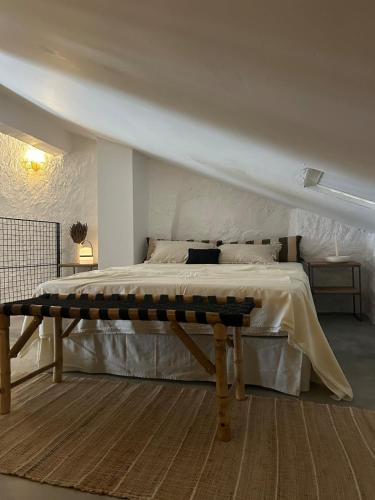 a bedroom with a large bed with a wooden bench at Casa el Estanco in Barracas