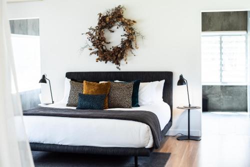 a bedroom with a bed with a wreath on the wall at The Woods Pokolbin in Pokolbin