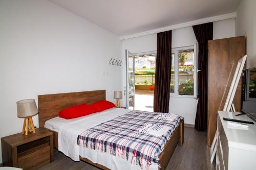 a bedroom with a large bed with a red pillow at Apartments Stevo Nikočević in Bar