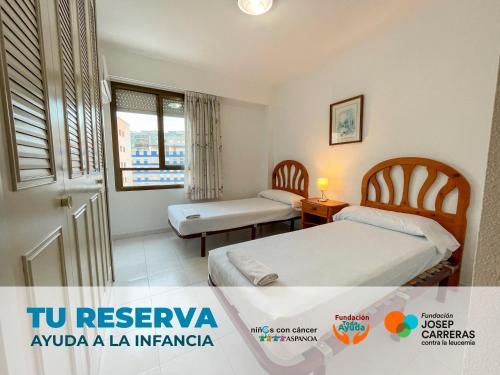 a hotel room with two beds and a window at Apartamentos Riviera 3000 in Benicàssim