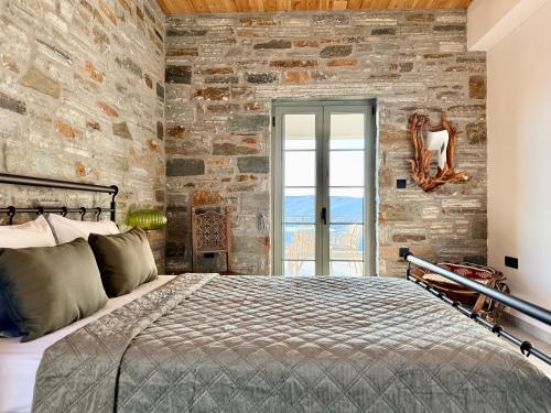 a bedroom with a stone wall and a bed at Agnandio Retreat Euboea in Animborió