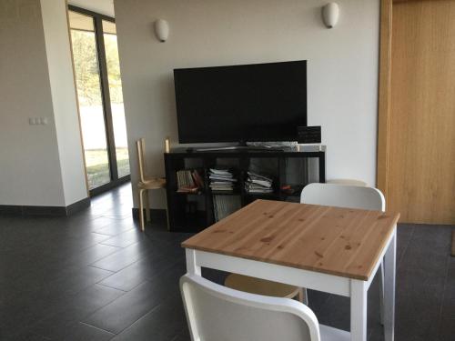 a living room with a table and a flat screen tv at Linar Do Rei in Linares