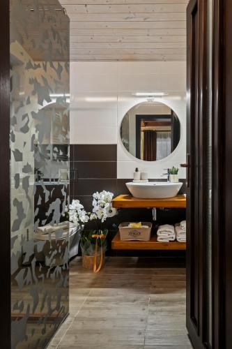 a bathroom with a sink and a mirror at Drago Chalet Sinaia, hot tub and sauna in Sinaia