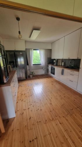 a large kitchen with wooden floors and a large window at Happy place in Kitee